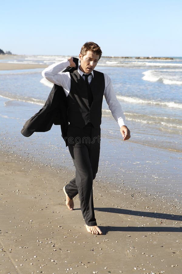 businessman-suit-walking-barefoot-beach-15241512.jpg